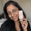 Anjali R, verified buyer with deep skin, holding the Tone Adapting CC Serum